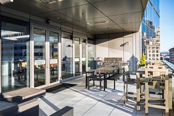 Outdoor terrace overlooking director park, with a fireplace feature and grilling station